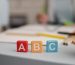 front-view-letters-cubes-with-defocused-tutoring-session-back